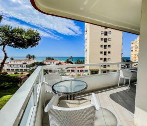 a balcony with a table and chairs and the ocean at Front Americano in Torrox Costa