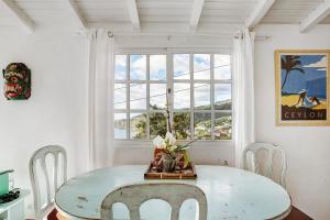 a dining room with a table and a window at Sunset Cliffs By Slice Of Heaven in Ribeira Brava