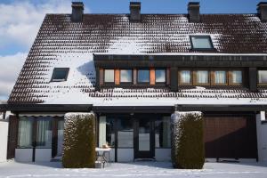 a house in the snow with a table in front of it at Ferienhaus Hochtal in Bernau im Schwarzwald