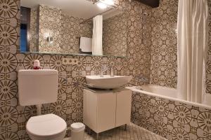 a bathroom with a toilet and a sink and a tub at Ferienhaus Hochtal in Bernau im Schwarzwald