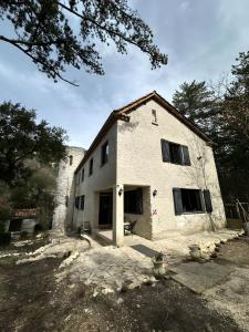 a white brick house with windows on a yard at Le Saint Marquan in Brantes