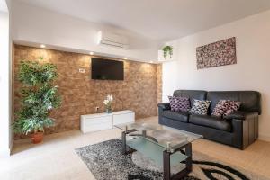 a living room with a couch and a tv on a wall at Rr Villa in Monforte del Cid