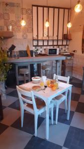 a kitchen with a white table and chairs with oranges on it at Le Saint Marquan in Brantes +22 photos
