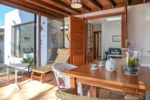 a dining room with a wooden table and chairs at Bungalow Playa Bastián in Costa Teguise