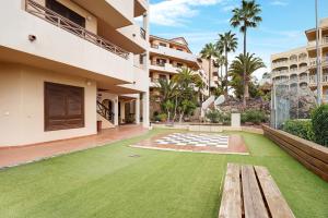 a lawn in the courtyard of a building with a bench at Cathamarcella in San Miguel de Abona