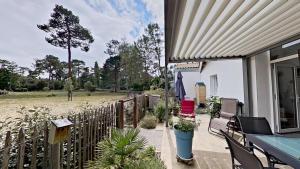 a porch of a house with a fence and plants at La maison de Fabien - Piscine in La Tranche-sur-Mer