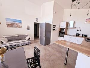 a kitchen and living room with a couch and a table at La maison de Fabien - Piscine in La Tranche-sur-Mer +3 photos