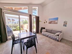 a living room with a table and chairs and a couch at La maison de Fabien - Piscine in La Tranche-sur-Mer