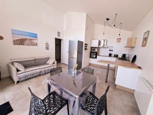 a living room with a couch and a table and chairs at La maison de Fabien - Piscine in La Tranche-sur-Mer