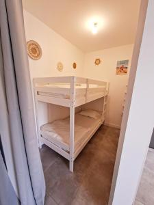 a bunk bed in a room with a curtain at La maison de Fabien - Piscine in La Tranche-sur-Mer