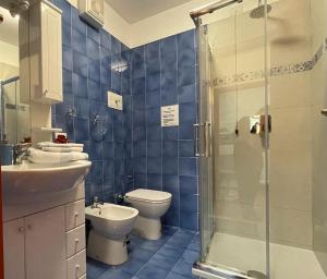a blue tiled bathroom with a toilet and a shower at Casa Jessika in Gardone Riviera +21 photos