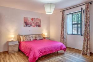 a bedroom with a pink bed and a window at Casa Rural Monte Dios in Jubrique +21 photos