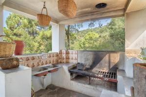 a kitchen with a grill and a sink and a window at Casa Rural Monte Dios in Jubrique