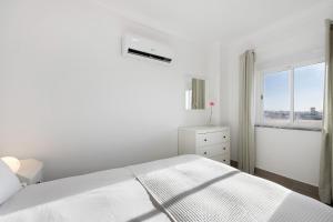a white bedroom with a bed and a window at Victoria's House in Sagres +20 photos