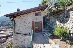 a small stone house with a door on a hill at Crotto Palma in Dongo