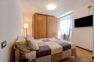 a bedroom with a bed in a room with a television at Crotto Palma in Dongo