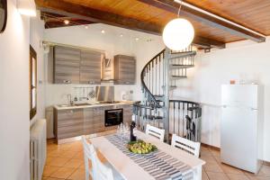a kitchen with a table and a spiral staircase at Crotto Palma in Dongo +12 photos