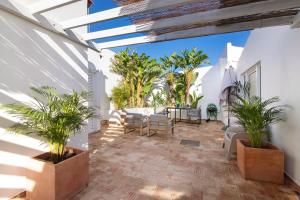 a patio with palm trees and a table and chairs at Estúdio Casa Do Limoeiro in Nora