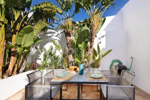 a table and chairs with plants in the background at Estúdio Casa Do Limoeiro in Nora