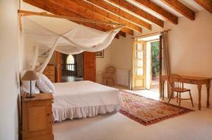 a bedroom with a canopy bed and a table and chairs at Sa Mesquida de D’alt in Capdepera +16 photos