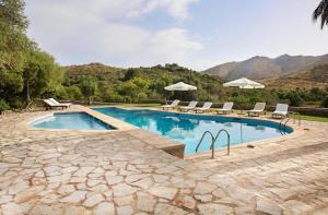 a swimming pool with chairs and umbrellas at Sa Mesquida de D’alt in Capdepera