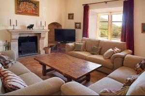 a living room with couches and a table and a fireplace at Sa Mesquida de D’alt in Capdepera