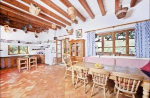 a kitchen and dining room with a wooden table and chairs at Sa Mesquida de D’alt in Capdepera