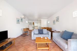 a living room with a couch and a tv at Apartamento Tavirasol in Tavira