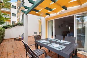 a dining table and chairs on a patio at Apartamento Tavirasol in Tavira