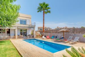 a house with a swimming pool and a palm tree at Villa Ronda Estación in Porreres