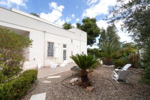 a white building with two chairs in a yard at Water Run in Bari