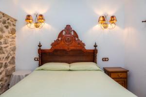 a bed in a room with two lights on the wall at Ca Sa Padrineta in Capdepera +17 photos