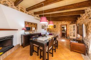 a kitchen with a dining table and a fireplace at Ca Sa Padrineta in Capdepera