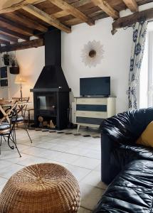a living room with a couch and a fireplace at Gîte De La Ferme Du Tilleul in La Pellerine