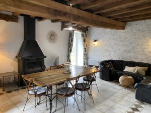 a living room with a wooden table and a fireplace at Gîte De La Ferme Du Tilleul in La Pellerine