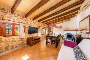 a large living room with a table and a tv at Ca Sa Padrineta in Capdepera