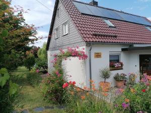 a small white house with flowers in the yard at Ferienwohnung Seilerberg in Freiberg