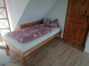 a bedroom with a bed with purple sheets and a wooden door at Ferienwohnung Seilerberg in Freiberg