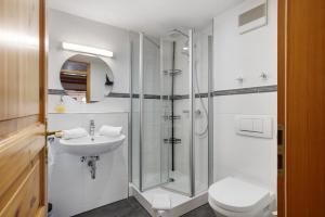 a bathroom with a shower and a toilet and a sink at Gästehaus Klingele in Todtmoos +70 photos