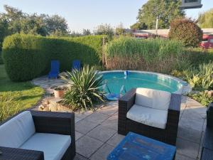 a backyard with a pool with two chairs and a table at Ferienwohnung Seilerberg in Freiberg