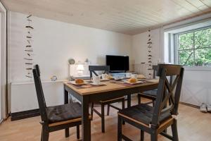 a dining room with a wooden table and chairs at Ferienwohnung Alte Bauernkate in Süderholz