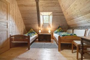 a room with two beds in a wooden cabin at Ferienwohnung Alte Bauernkate in Süderholz