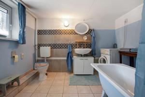 a bathroom with a tub and a toilet and a sink at Ferienwohnung Alte Bauernkate in Süderholz +25 photos