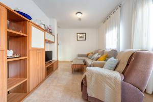a living room with a couch and a tv at Ca la Mercè in Camarles
