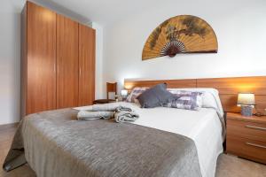 a bedroom with a large bed and a wooden cabinet at Ca la Mercè in Camarles