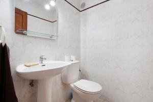 a white bathroom with a toilet and a sink at Casa Rosi in Gran Tarajal +4 photos