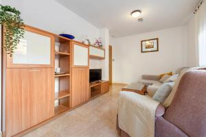 a living room with a couch and a tv at Ca la Mercè in Camarles +12 photos