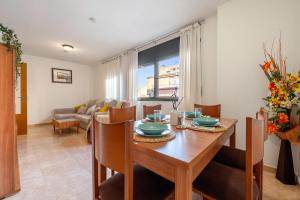 a dining room and living room with a table and chairs at Ca la Mercè in Camarles