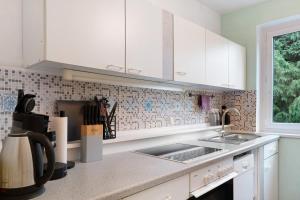 a kitchen with white cabinets and a sink at Amselnest in Kempten +13 photos