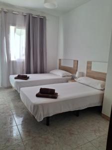 two beds in a room with towels on them at Casa Rosi in Gran Tarajal